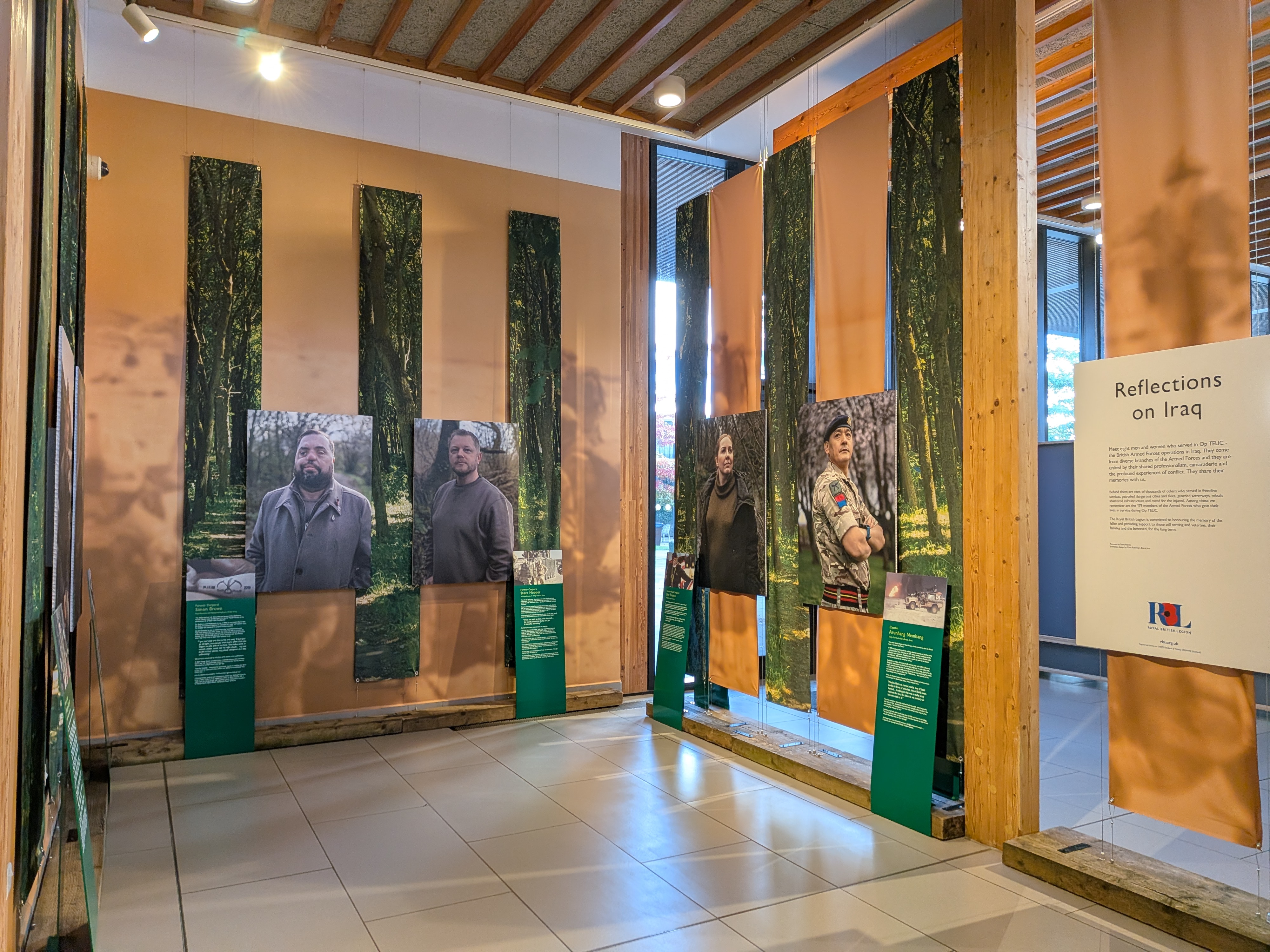 The gallery exhibition features a range of portraits hung on wooden panels