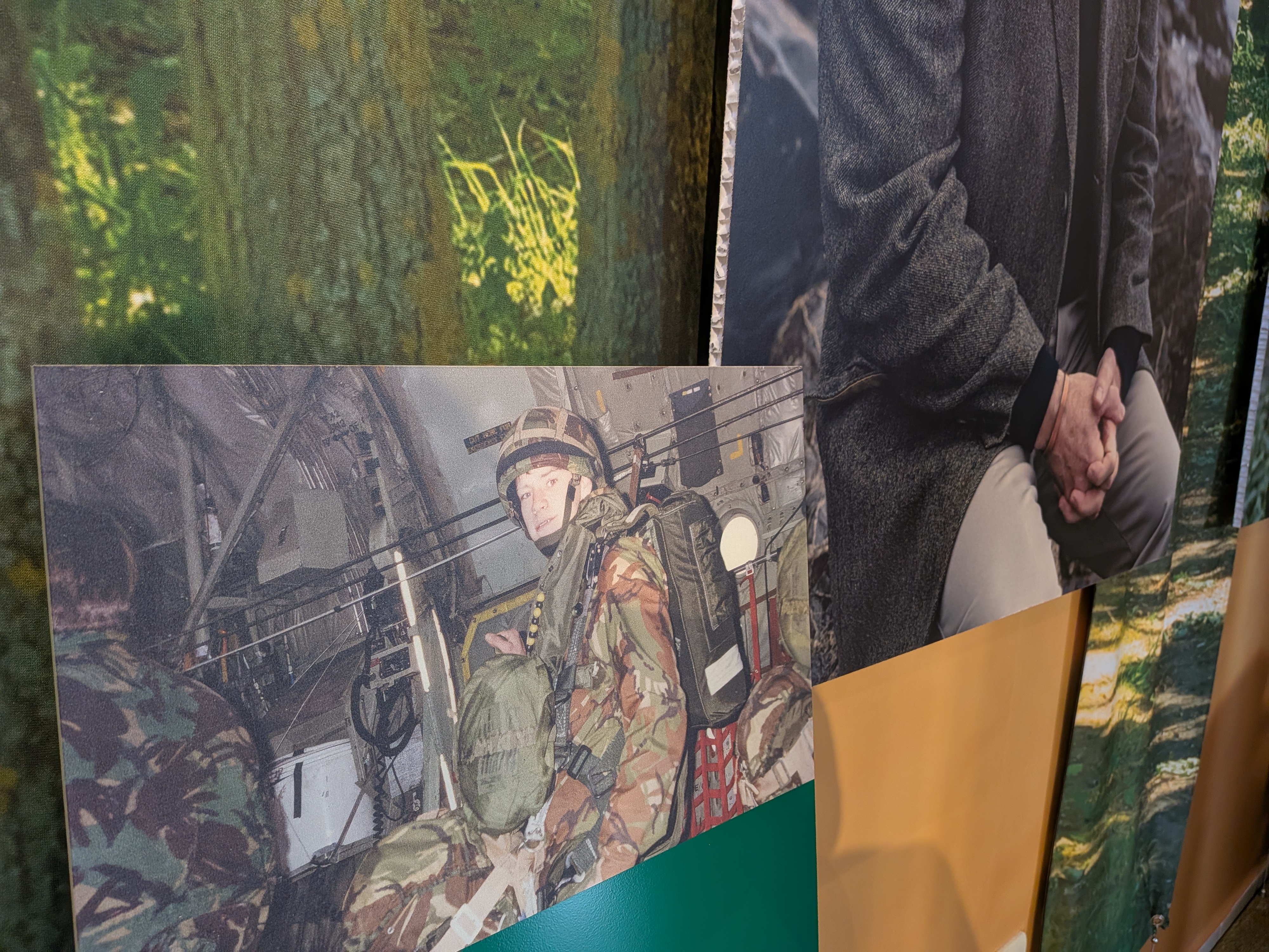 An image of a soldier in camouflage uniform in the back of an aircraft, on a wooden wall as part of the Reflections on Iraq portrait exhibition