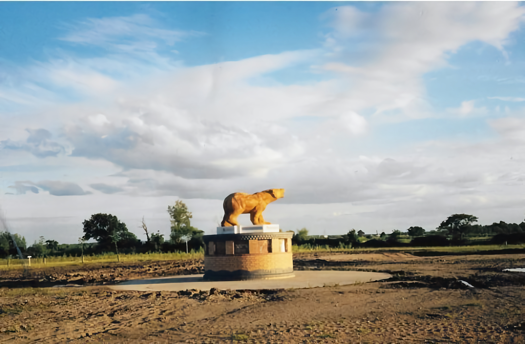 A historical photograph of the Polar Bear memorial, in a muddy field.