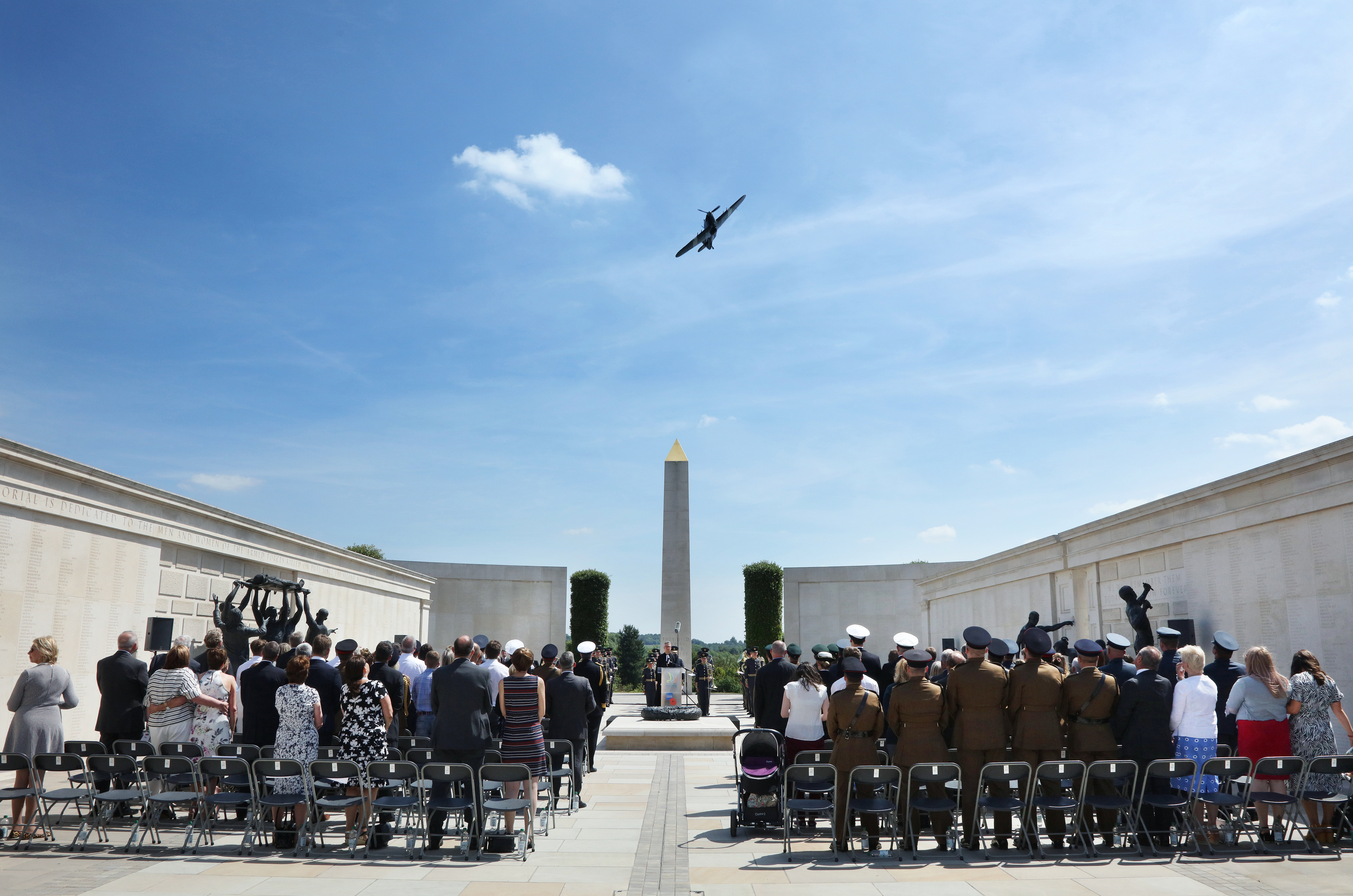 Flypast during an event on the Armed Forces Memorial. The crowd are stood, looking to the sky.