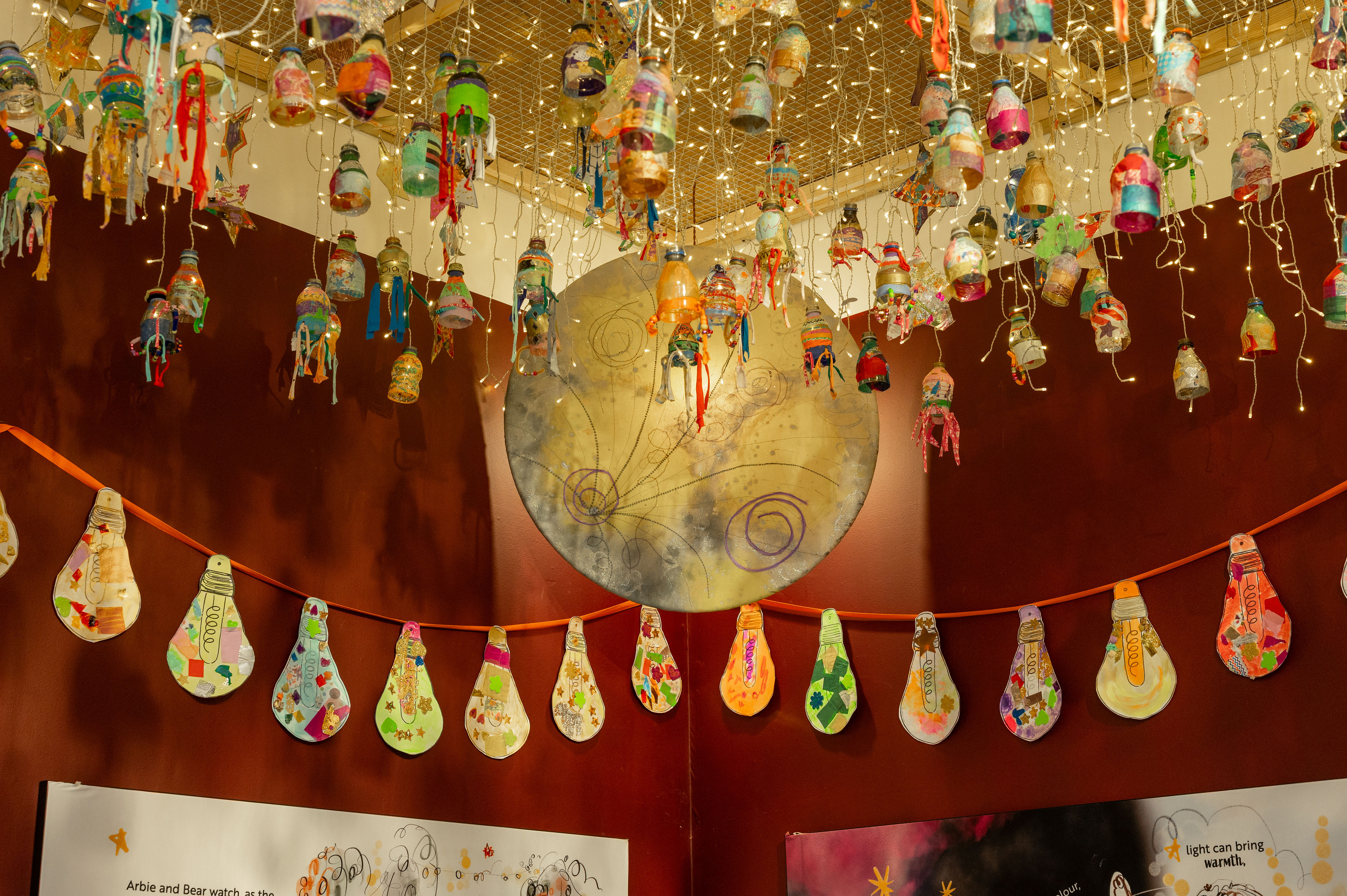 Nearly 1000 lanterns created by local school children from recycled plastic bottles hang from the ceiling.