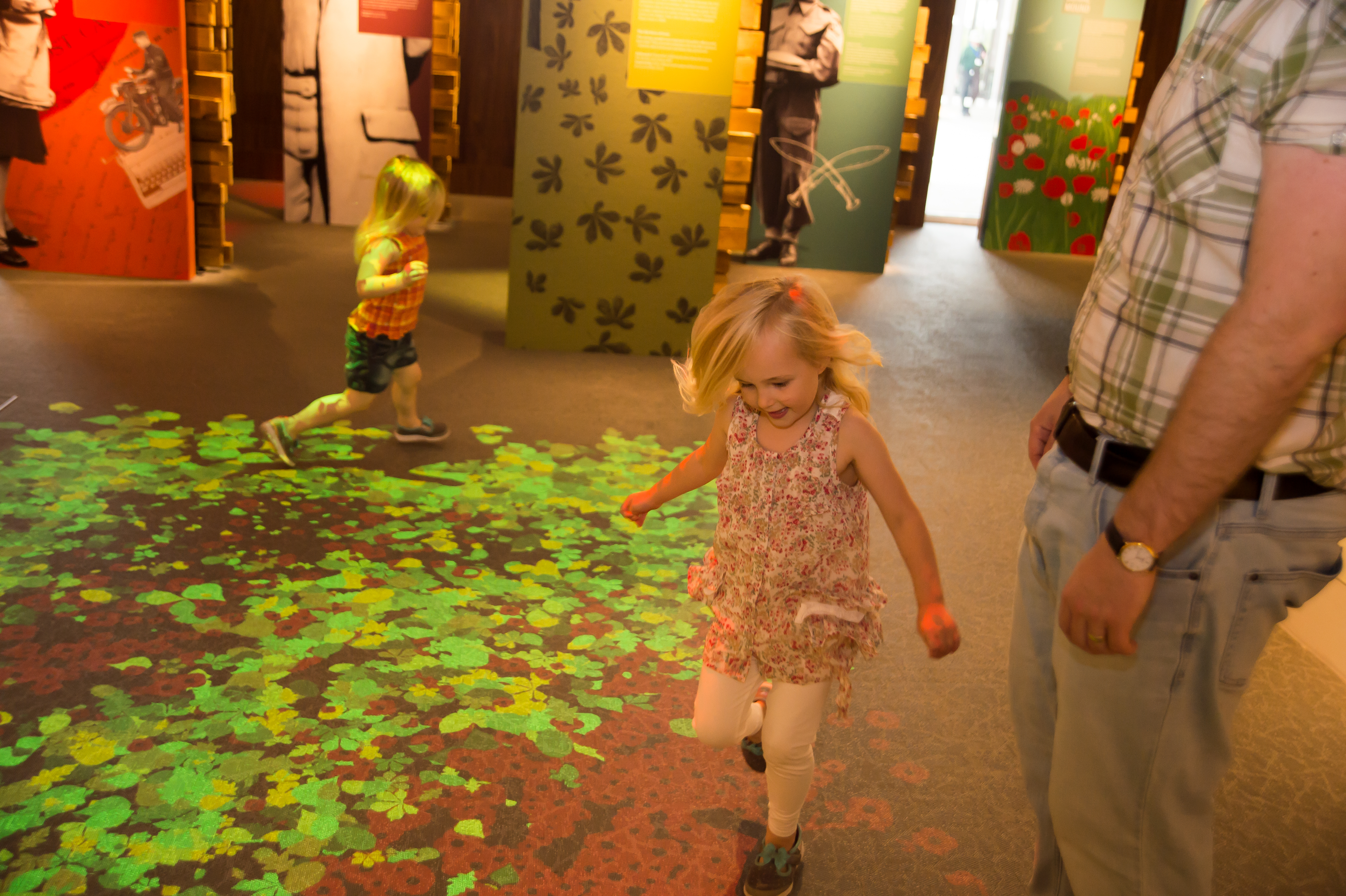 Children running through the interactive poppy floor