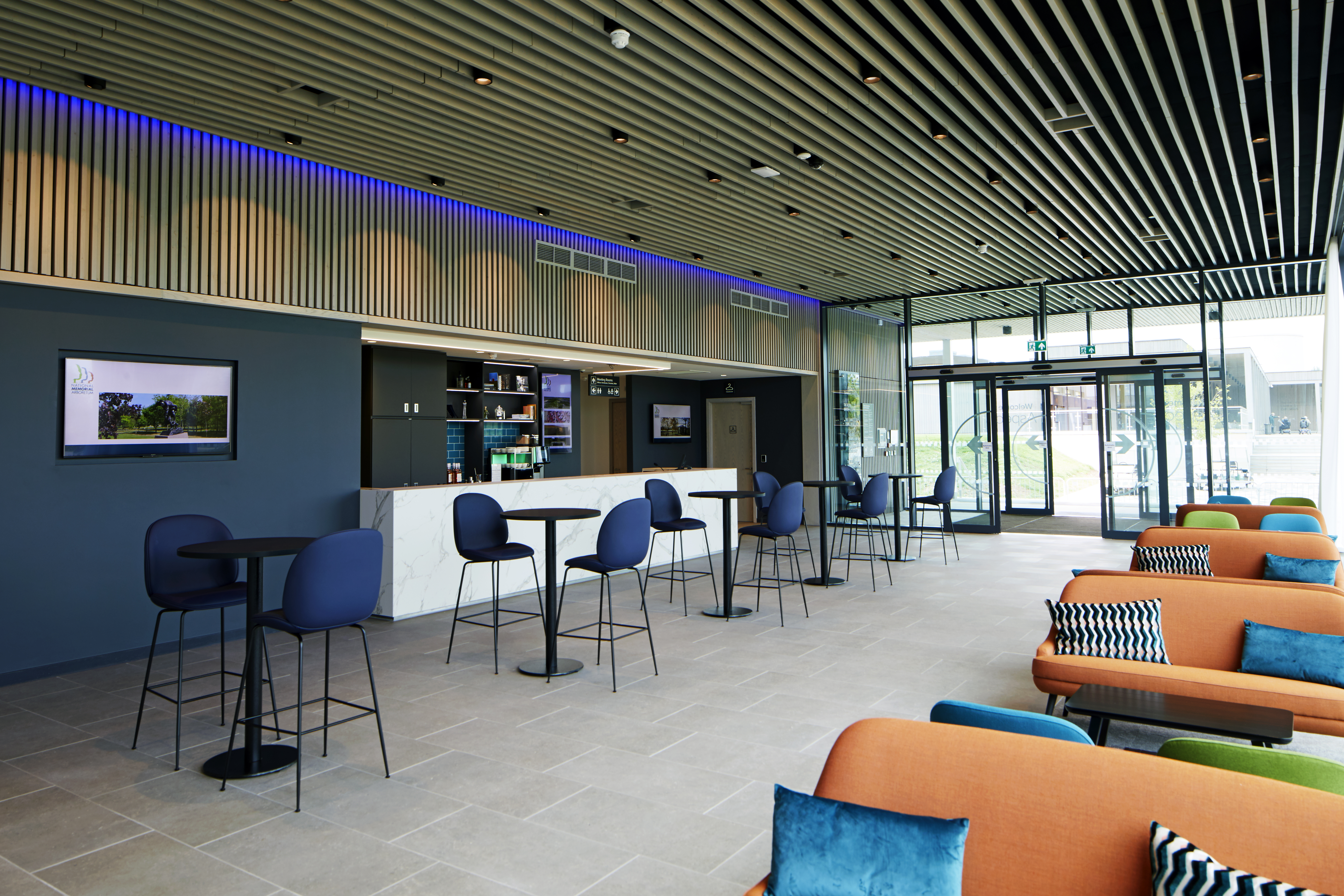 the bar area within Aspects, featuring a wide bar, standing tables and comfy sofa seating.