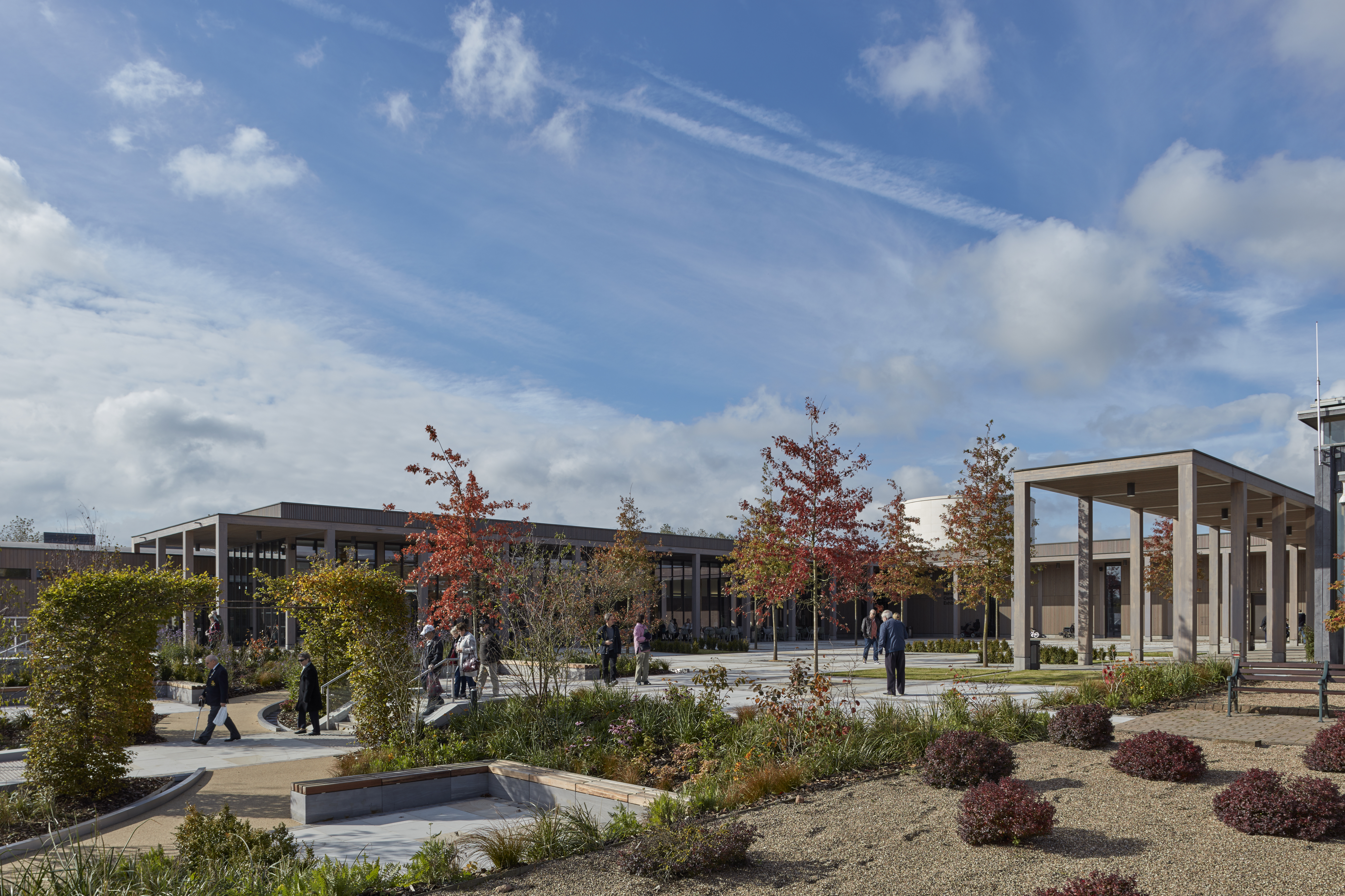 Heroes Square in autumn, with red oak trees and visitors walking down the stairs into the grounds.