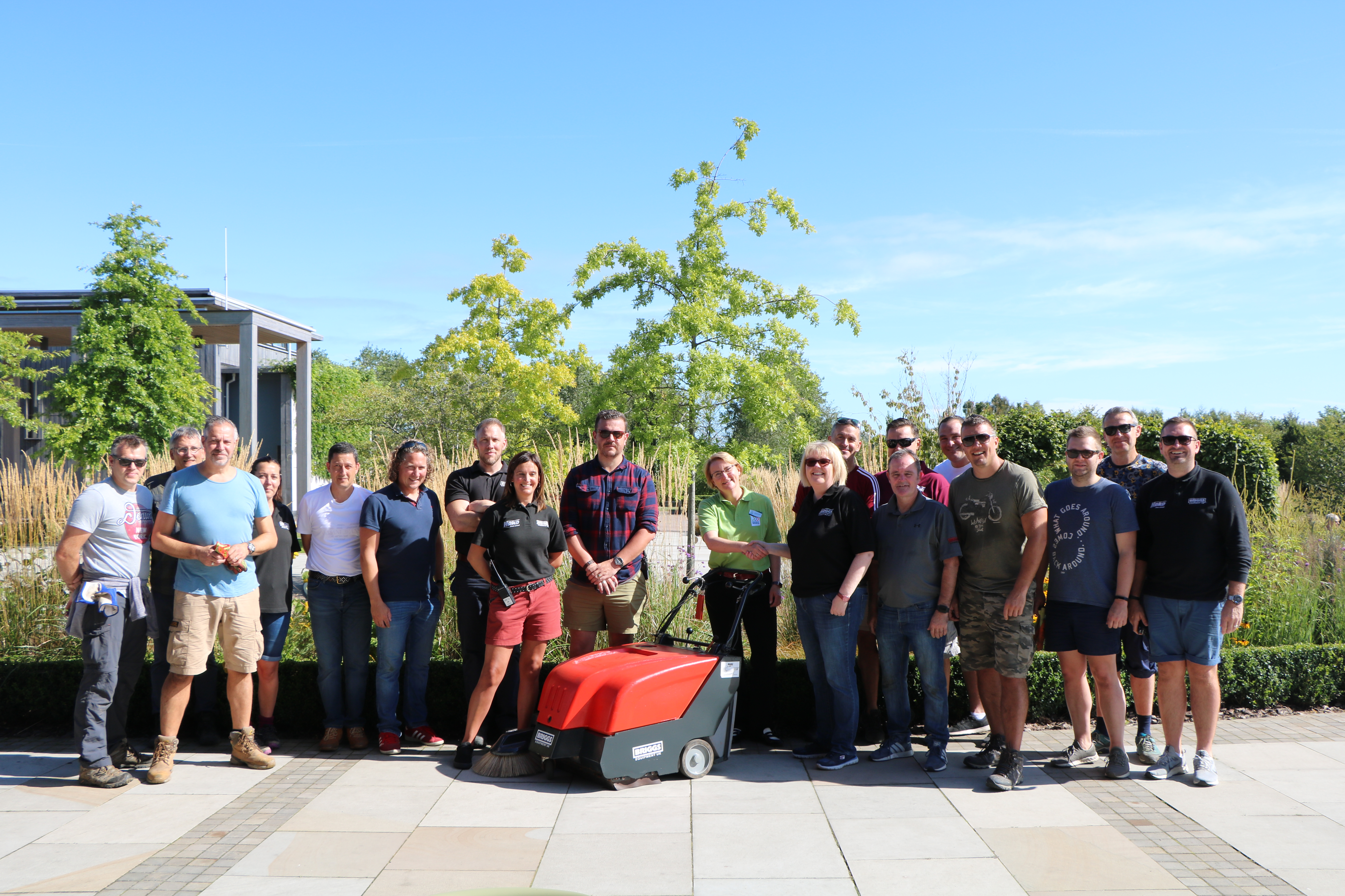 Briggs Equipment employees handing over the keys to a sweeper, gifted for use to the Arboretum.