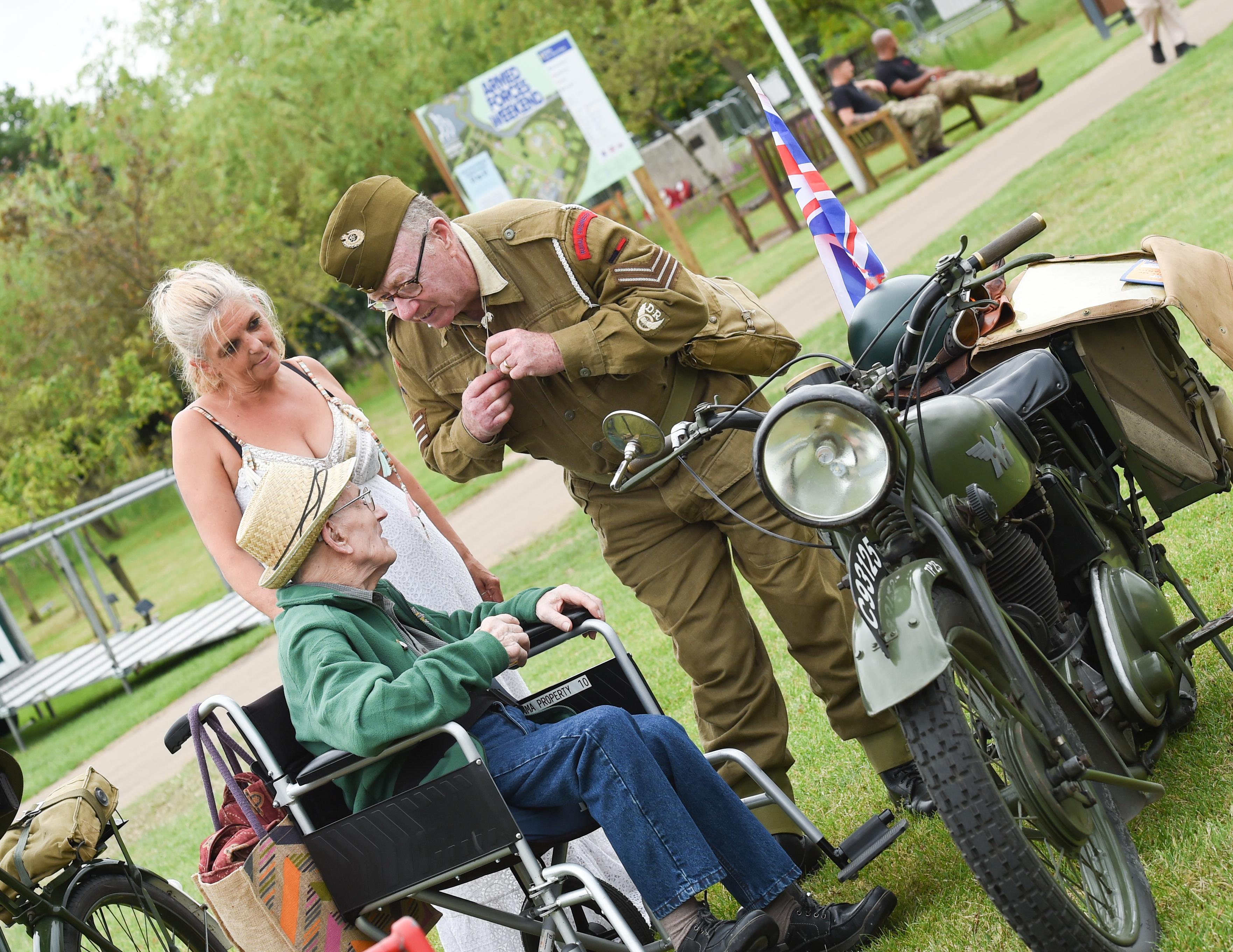 A WWII reinactor talking to an elderly veteran in a wheelchair
