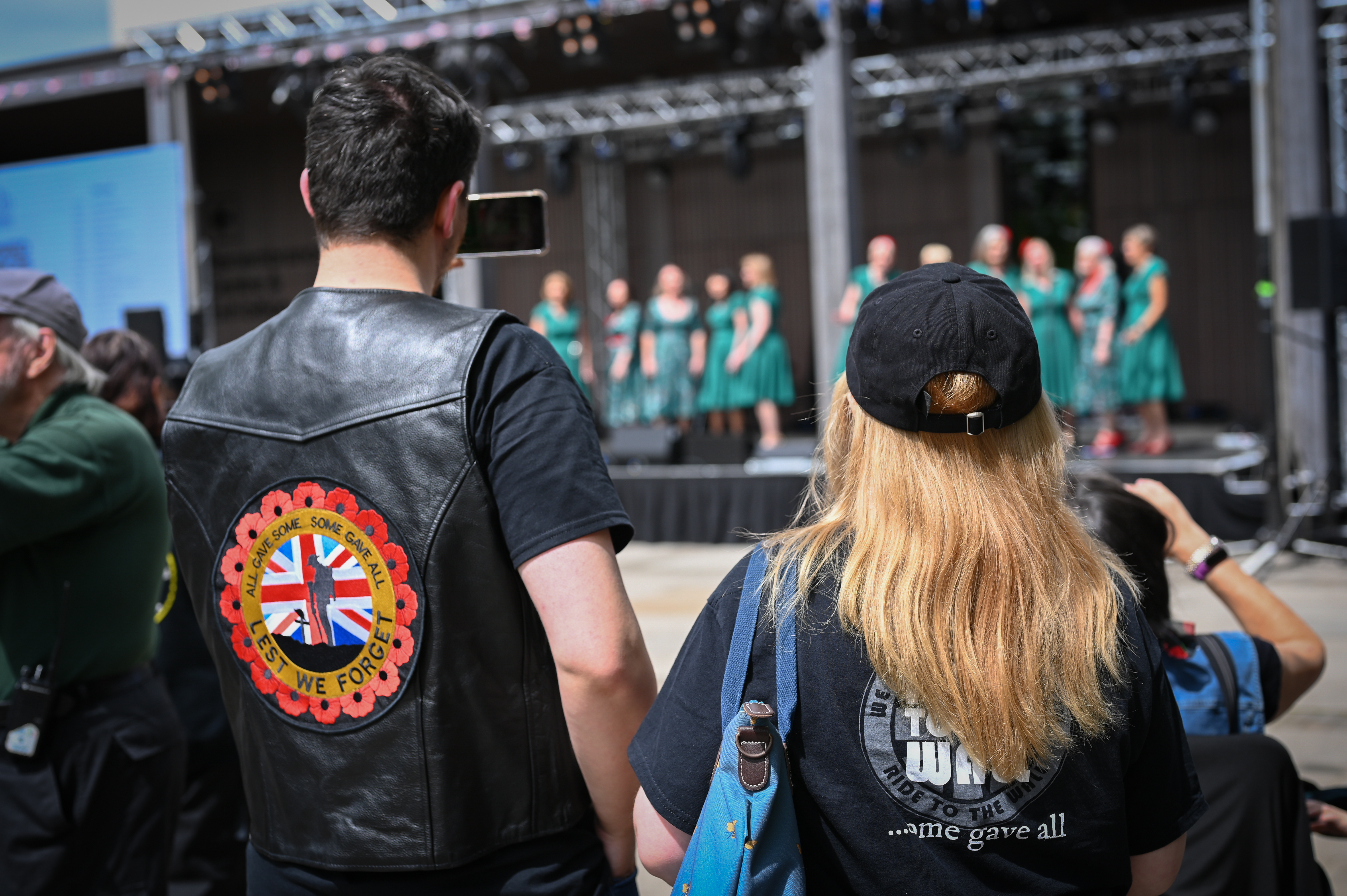 Heath Belles performing at Armed Forces Weekend, on a stage in Heroes Square. They are being watch by an audience.