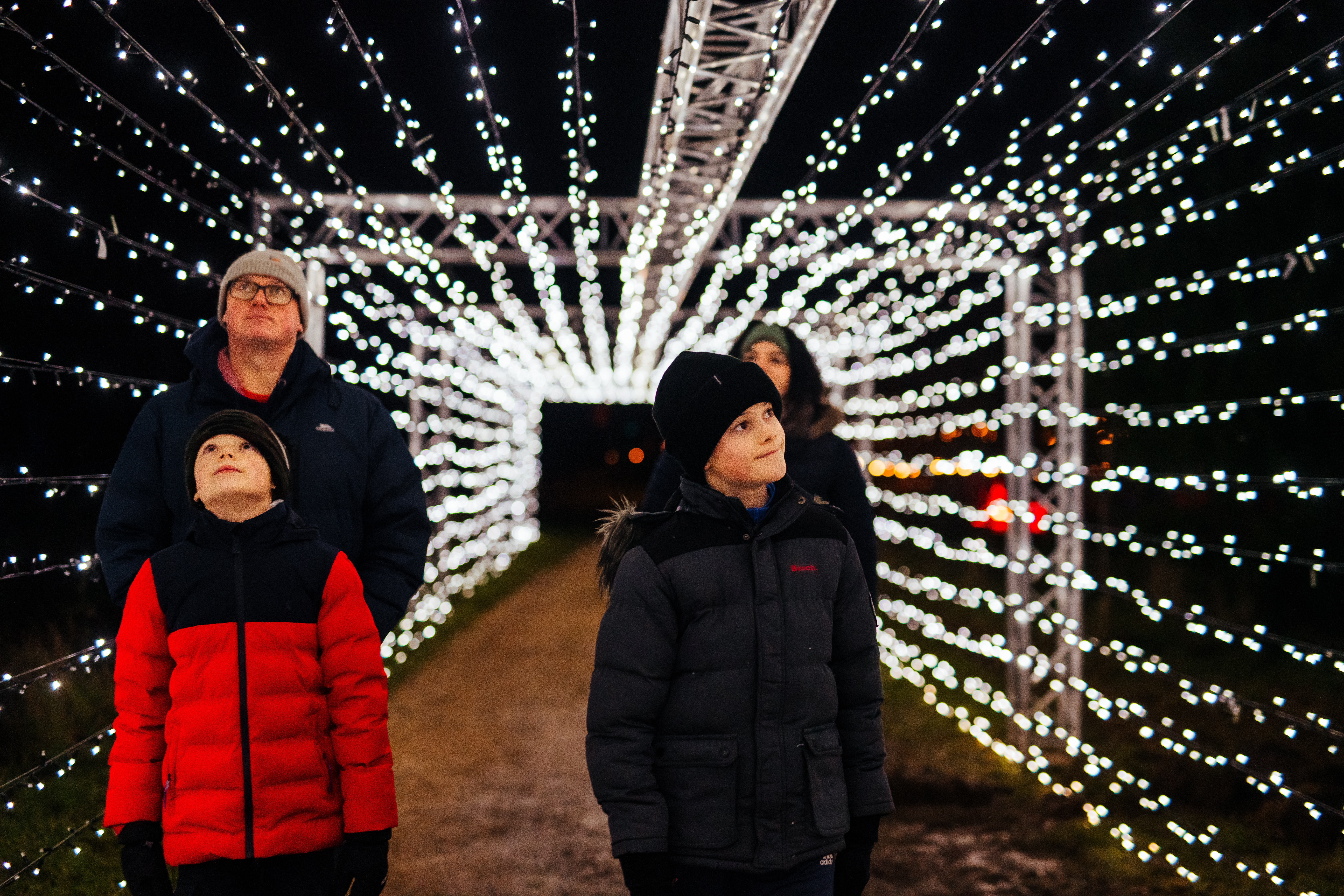 Family in the Illuminated Arboretum light tunnel
