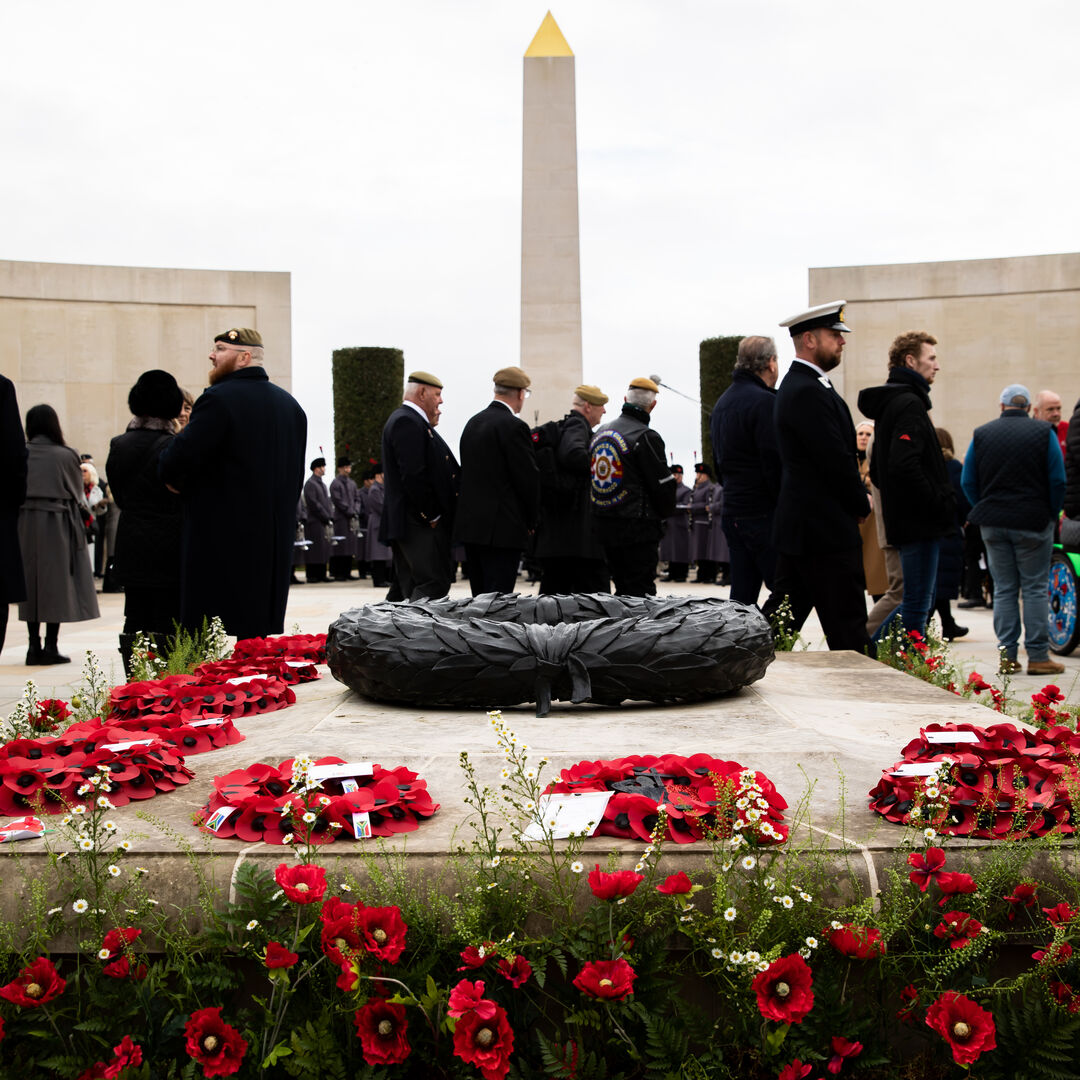 People on top of the Armed Forces Memorial on Remembrance Sunday in 2025. The Memorial is adorned with poppy displays.