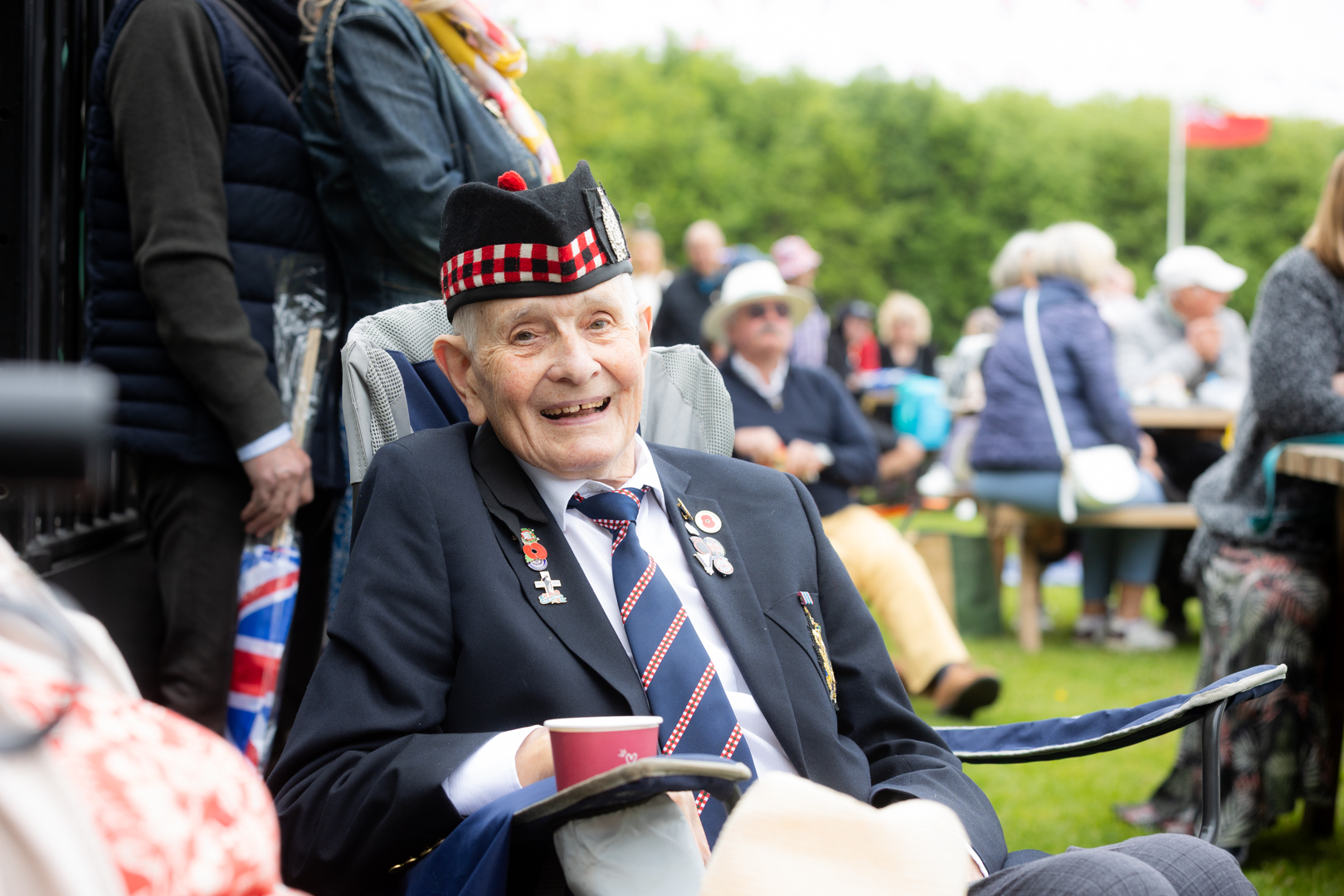 A veteran smiling and enjoying the festivities while sat in his wheelchair