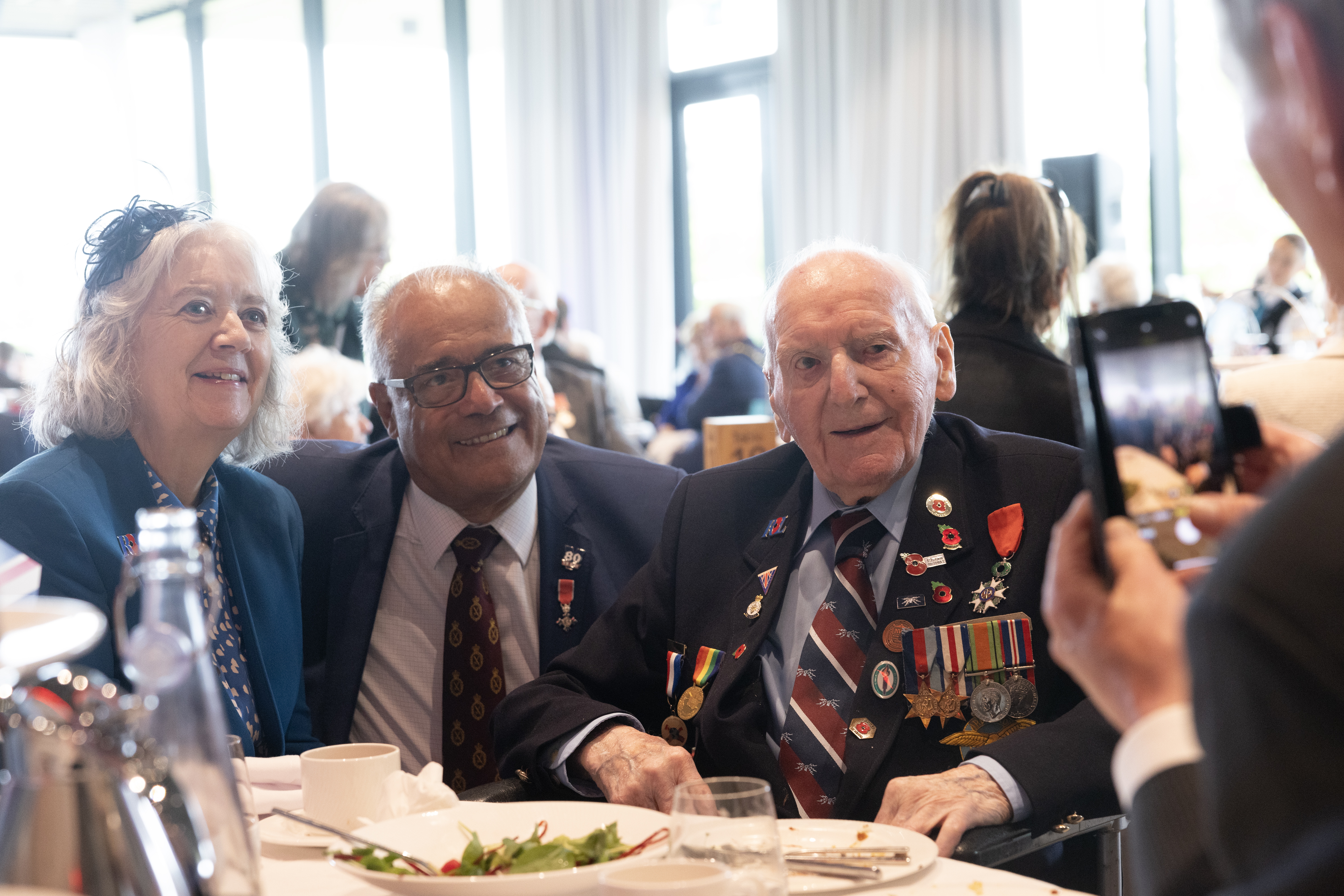 A second World War Campaign Veteran poses for a photograph with other guests at the RBL VE Day Tea Party