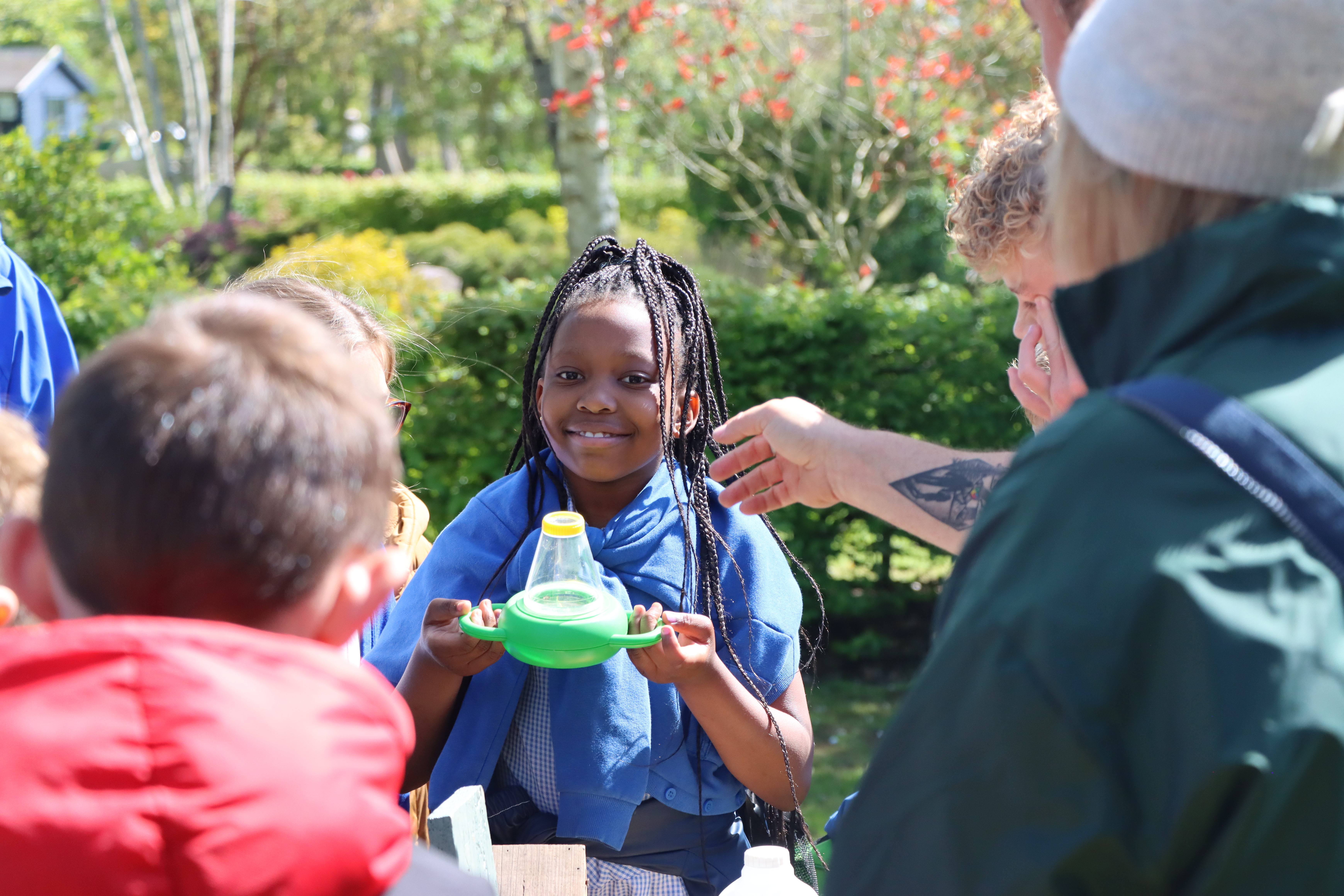 Children looking at worms through magnifying glasses at the Earth Day Free Activity Day for Schools