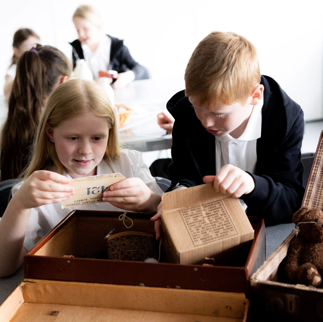 Ks2 Students looking at artefacts from the evacuation during WW2