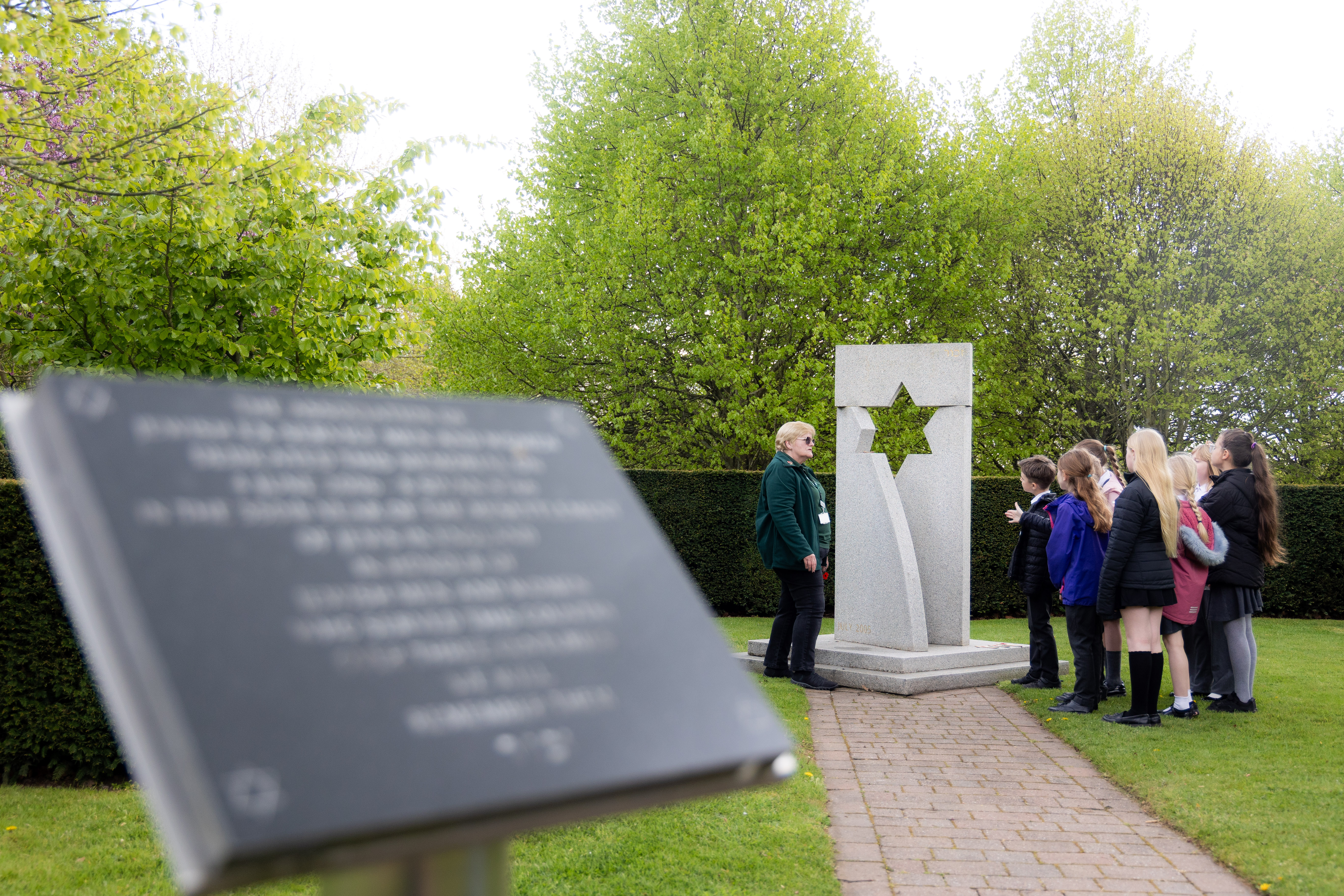 Students on a guided tour, looking at the AJex Memorial dedicated to Jewish service personnel