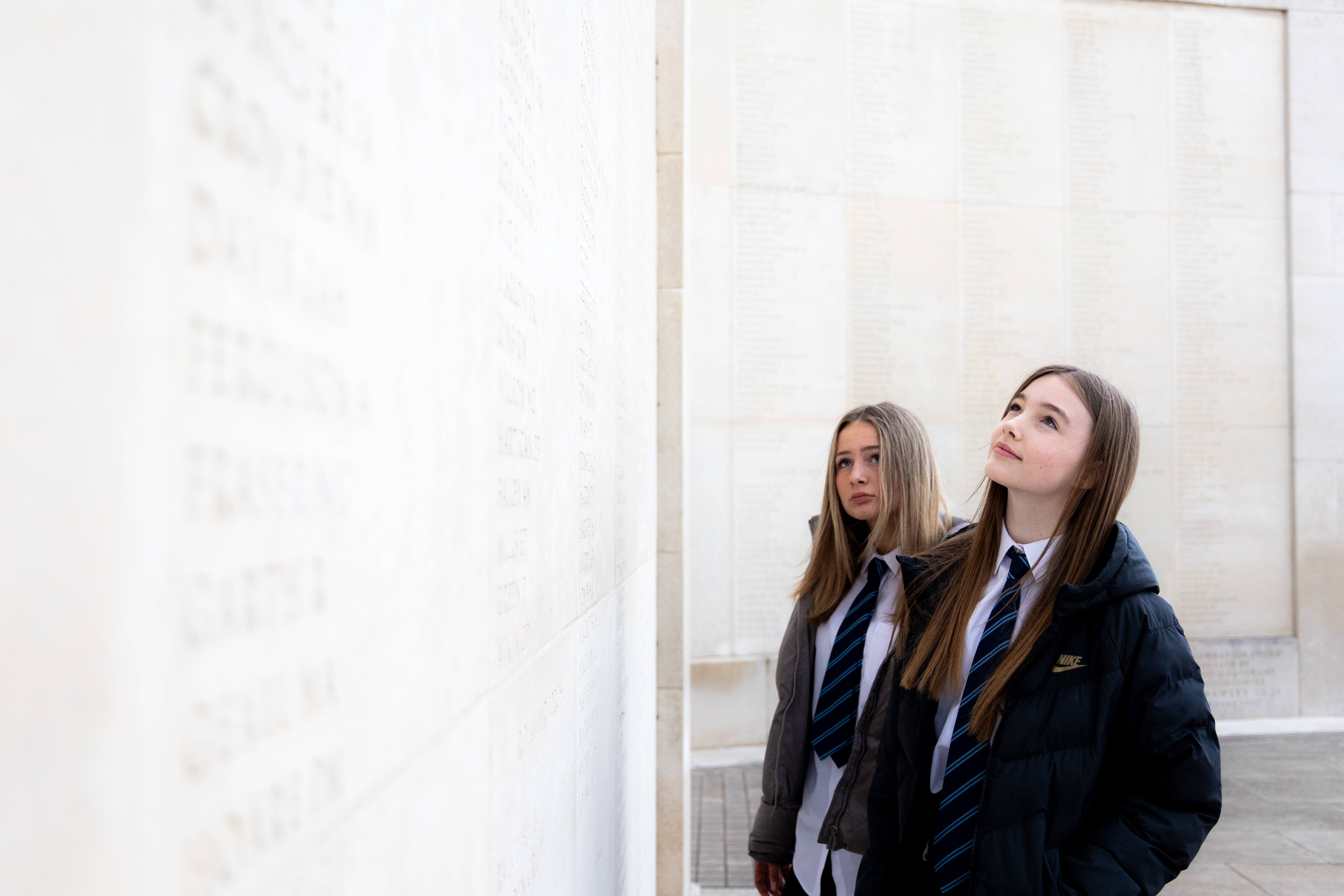 Key stage three students looking at names on the Armed Forces Memorial
