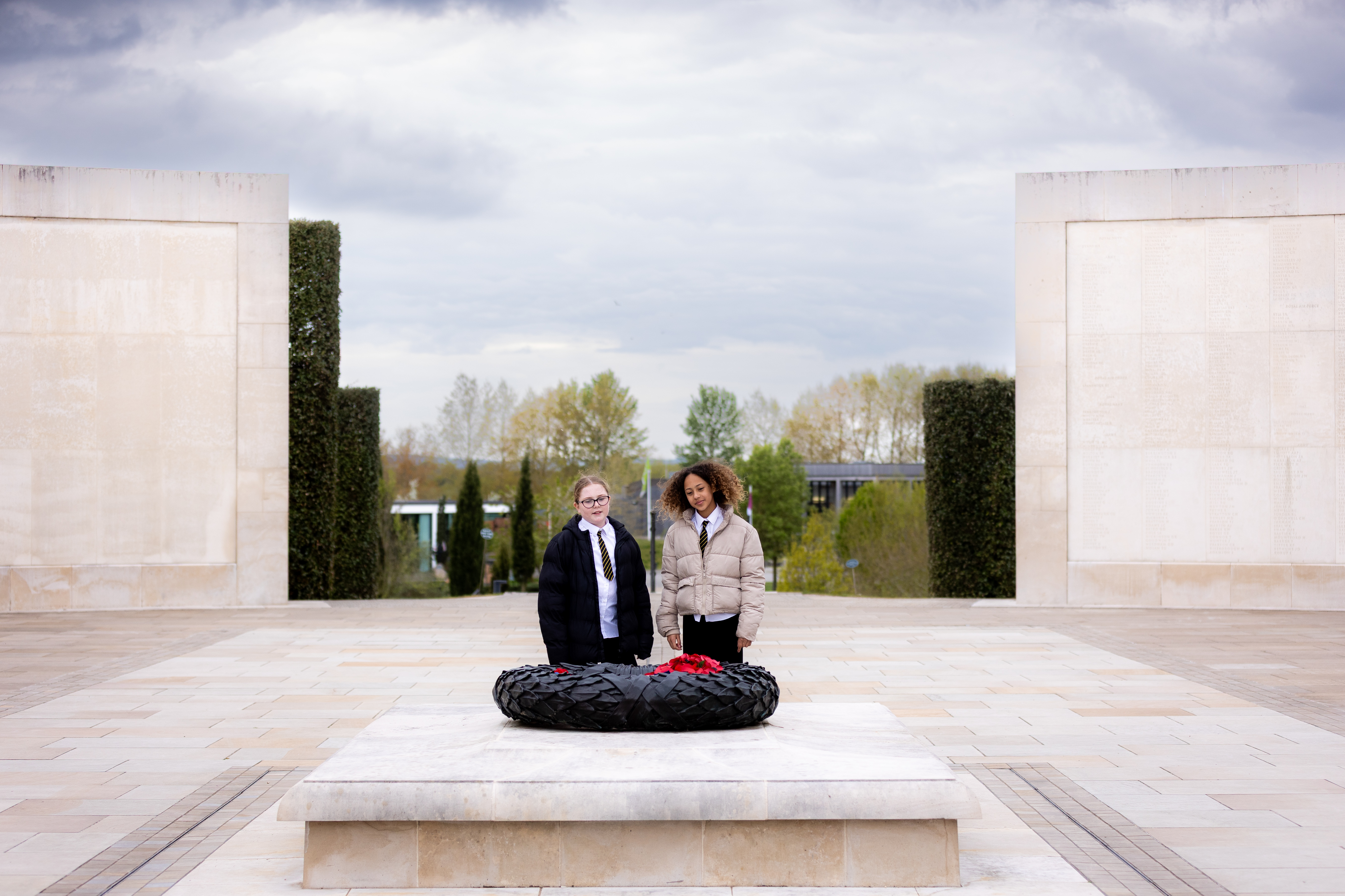 Key Stage Three students on the Armed Forces memorial, looking at the bronze wreath