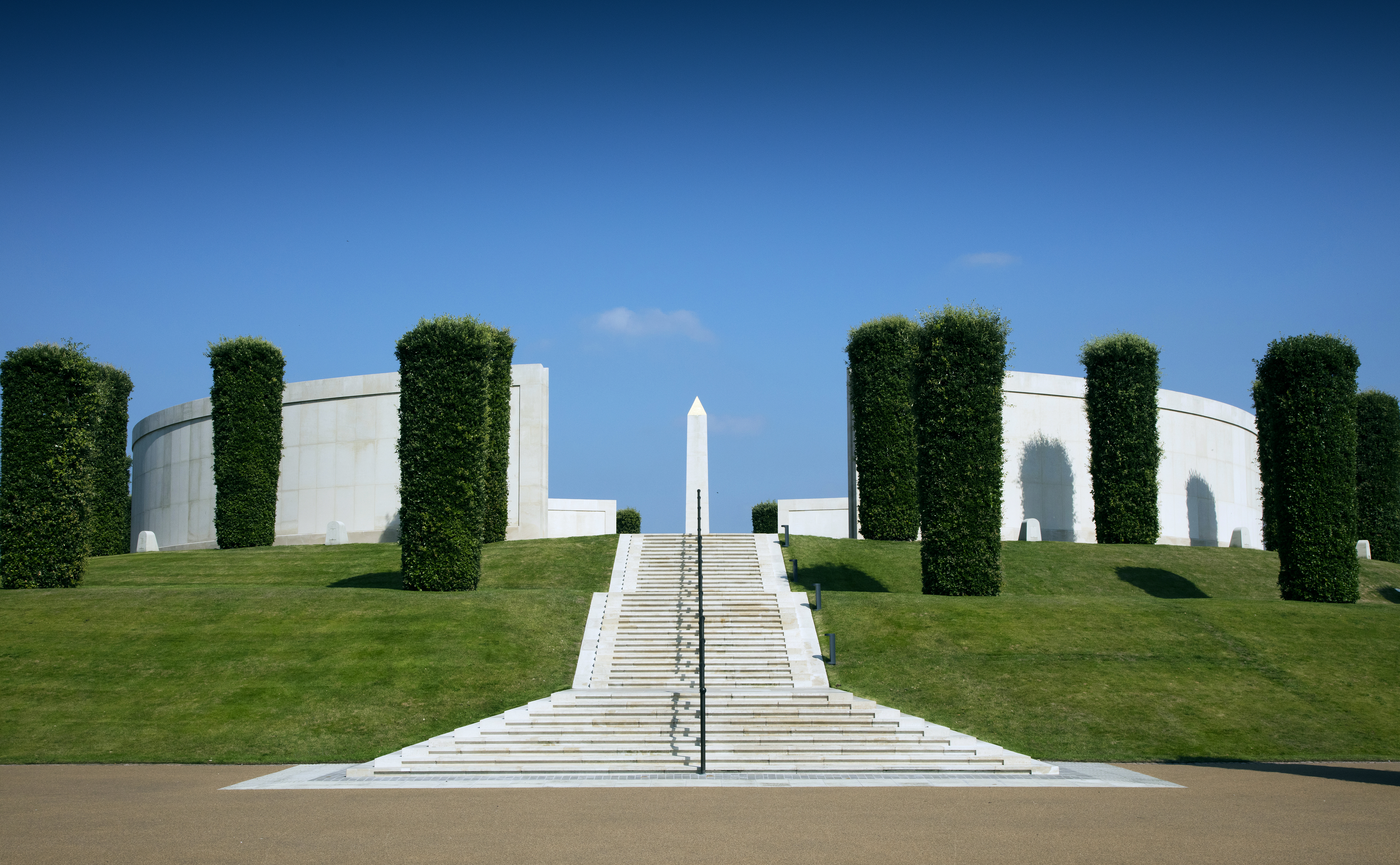 The white steps of the Armed Forces Memorial sit centrally in the frame, against a blue sky.