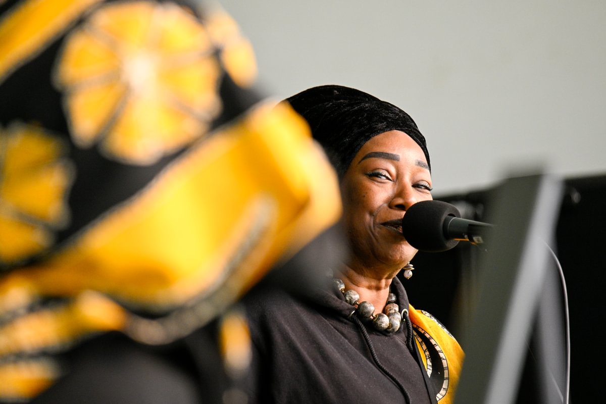 A member of black voices singing into a microphone