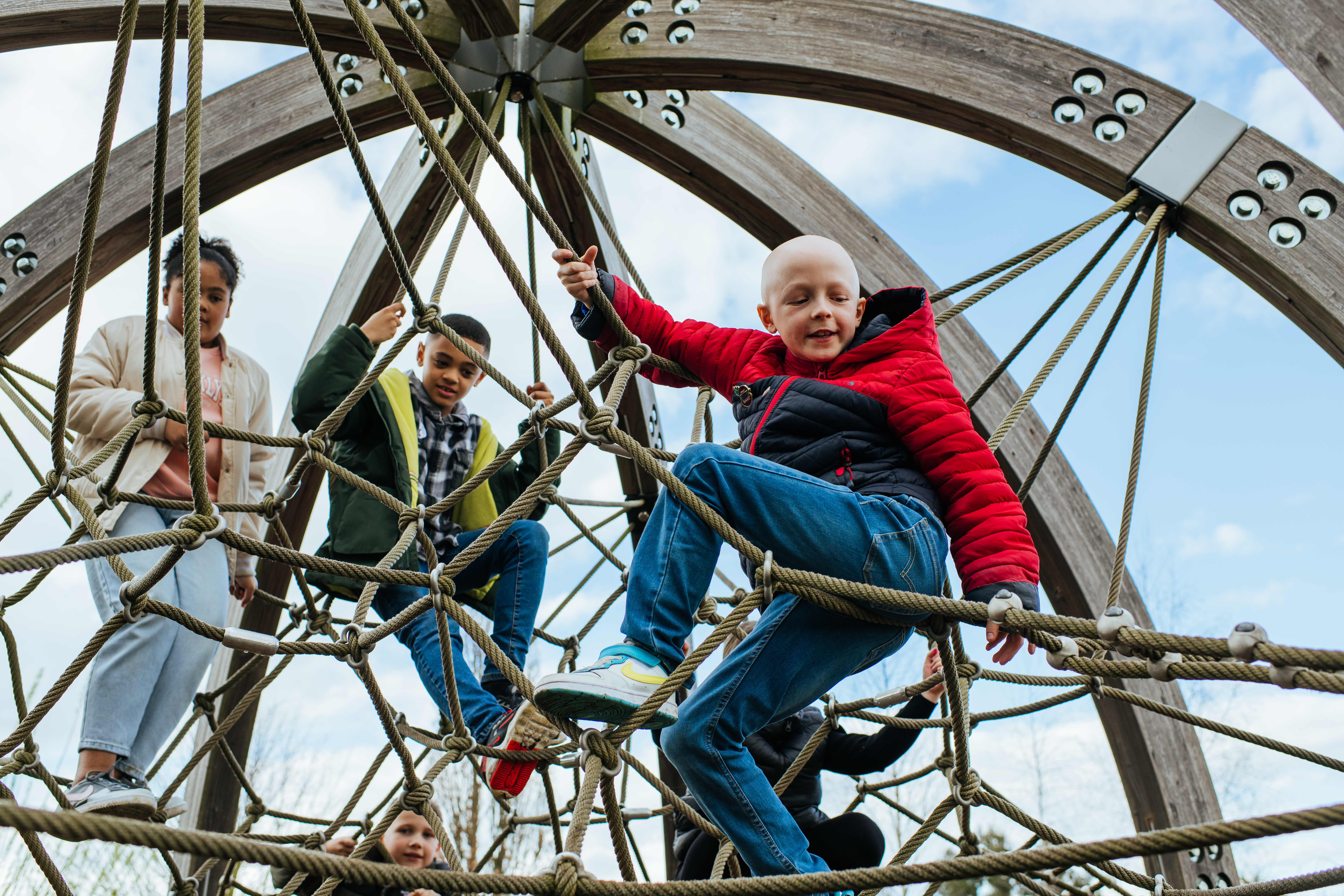 Three young children play on the Children's Sensory Play Garden