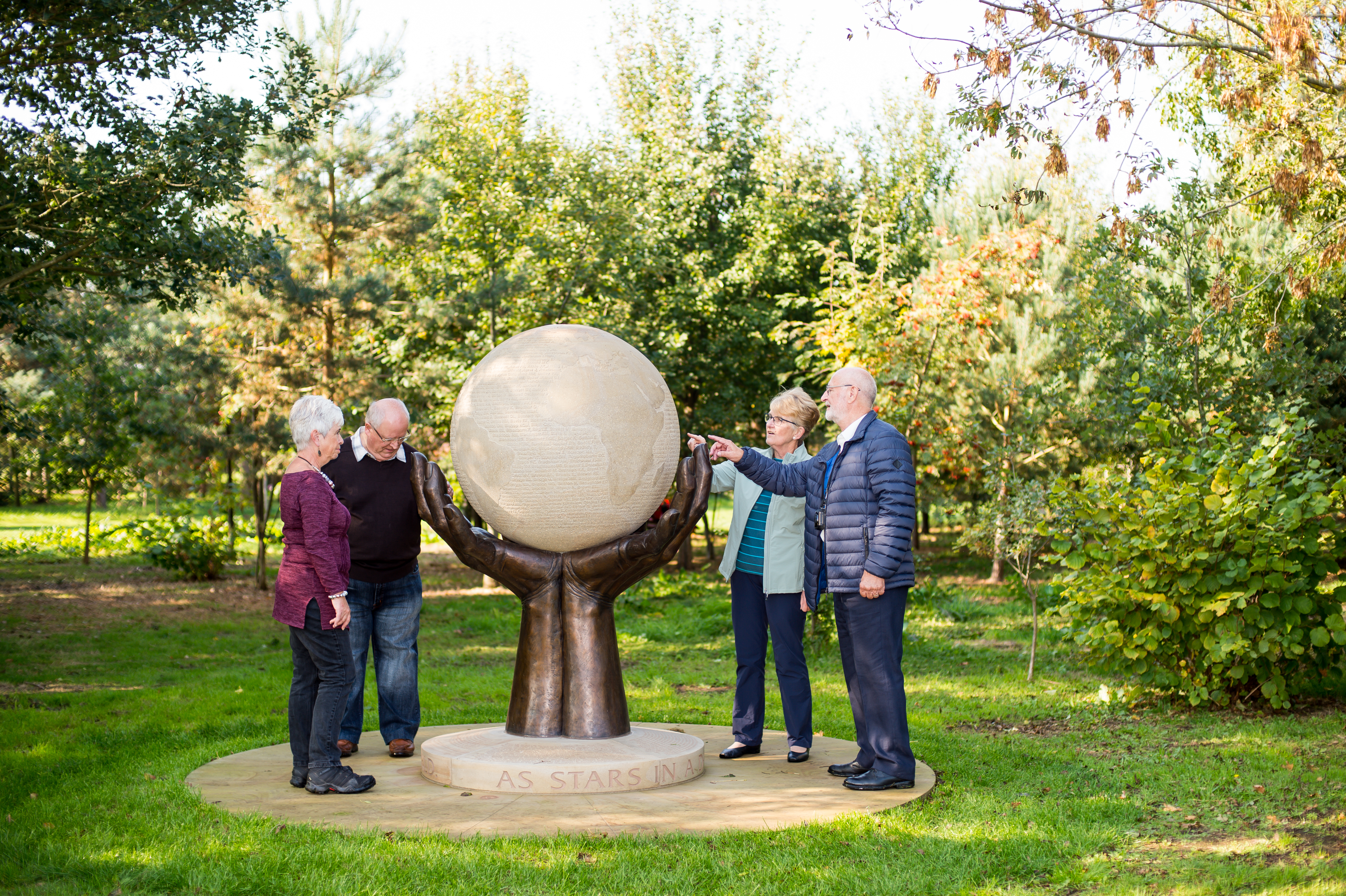 Group visitors at the National Remembrance Gardens look at the GCHQ memorial.
