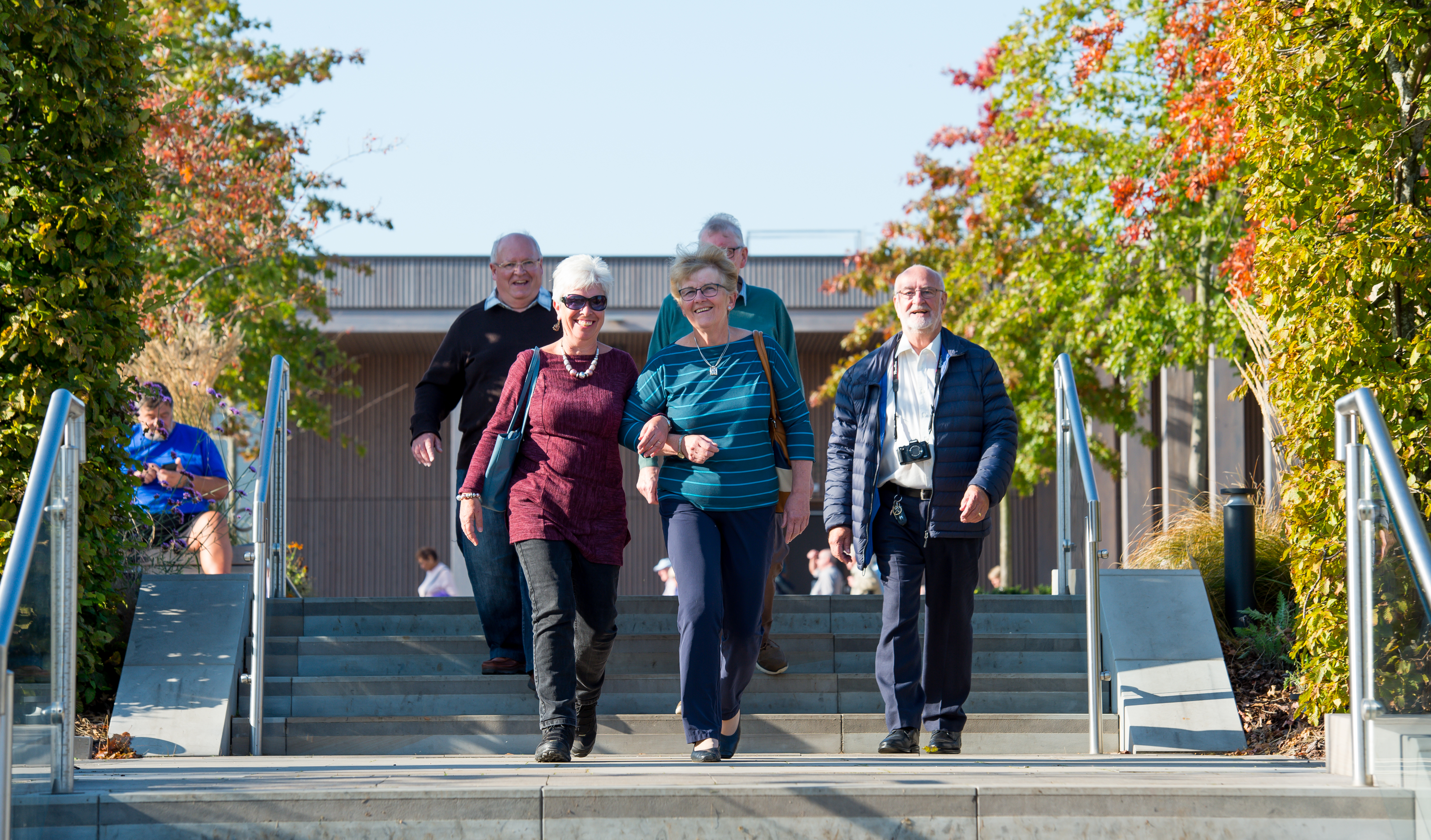 Group visitors at the National Remembrance Gardens walk down the steps in Heroes Square arm in arm.