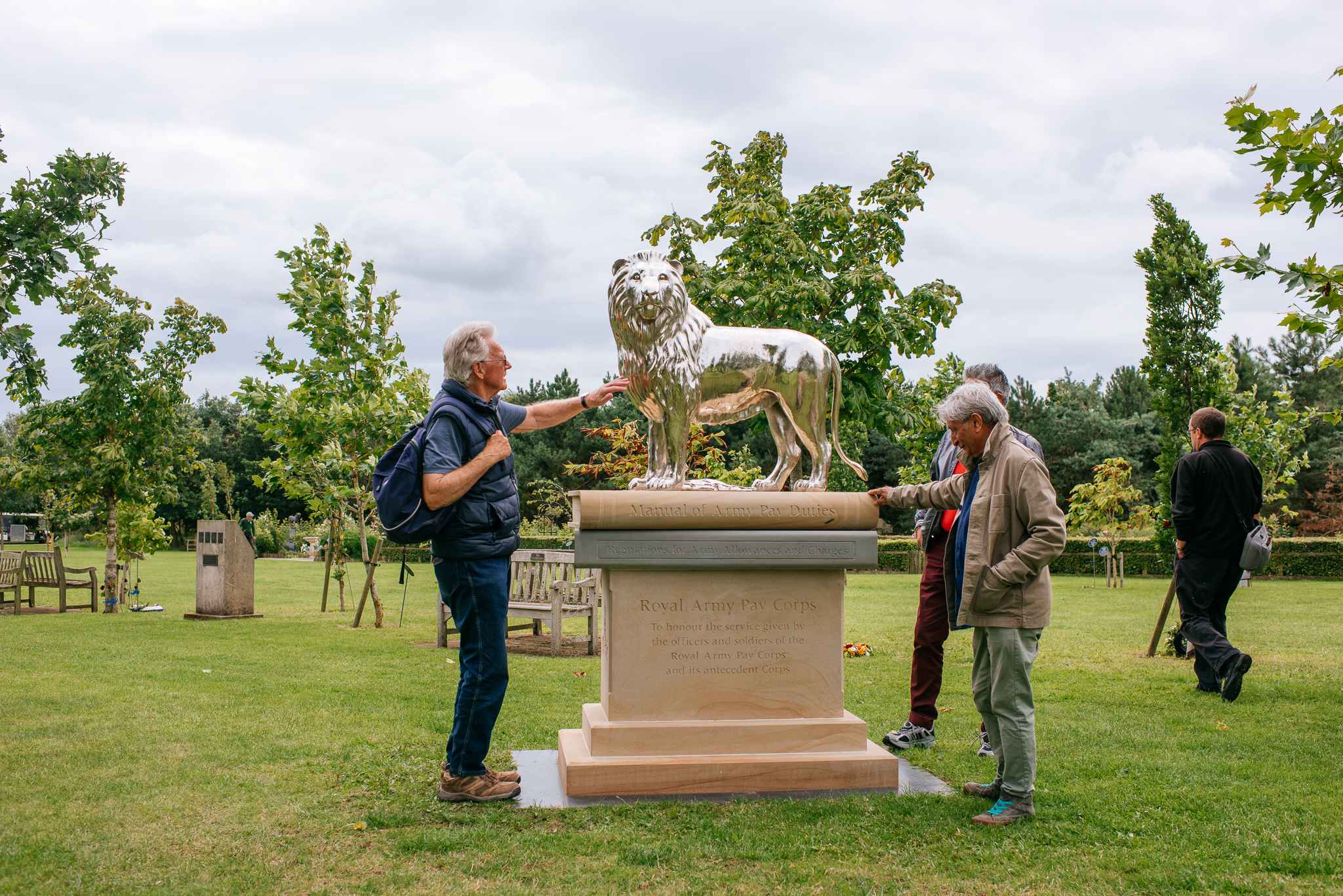 A group of people looking at the Royal Army Pay Corps Memorial